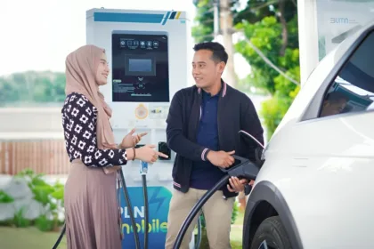 Pengguna mobil listrik tengah melakukan pengisian daya di Stasiun Pengisian Kendaraan Listrik Umum (SPKLU) PLN.