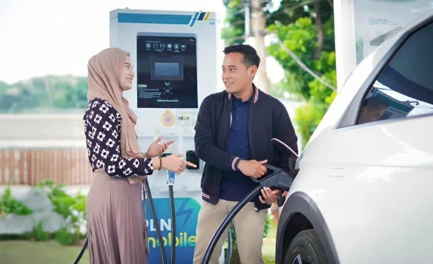 Pengguna mobil listrik tengah melakukan pengisian daya di Stasiun Pengisian Kendaraan Listrik Umum (SPKLU) PLN.