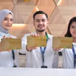 Tiga staf Pegadaian dengan ramah memamerkan replika buku rekening Tabungan Emas Pegadaian, layanan inovatif yang memungkinkan masyarakat menabung emas mulai dari 0,01 gram. Inisiatif ini menegaskan komitmen Pegadaian dalam menyediakan akses mudah dan aman bagi masyarakat untuk berinvestasi emas, mendukung perencanaan keuangan masa depan.
