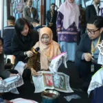 Rina Rahmayanti, S.Pd pemilik Rinara Batik sekaligus Local Hero PLN UID Banten, memandu para delegasi internasional mencoba teknik dasar membatik menggunakan canting.
