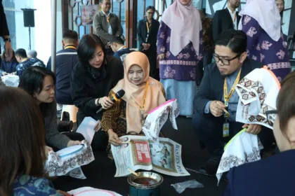 Rina Rahmayanti, S.Pd pemilik Rinara Batik sekaligus Local Hero PLN UID Banten, memandu para delegasi internasional mencoba teknik dasar membatik menggunakan canting.