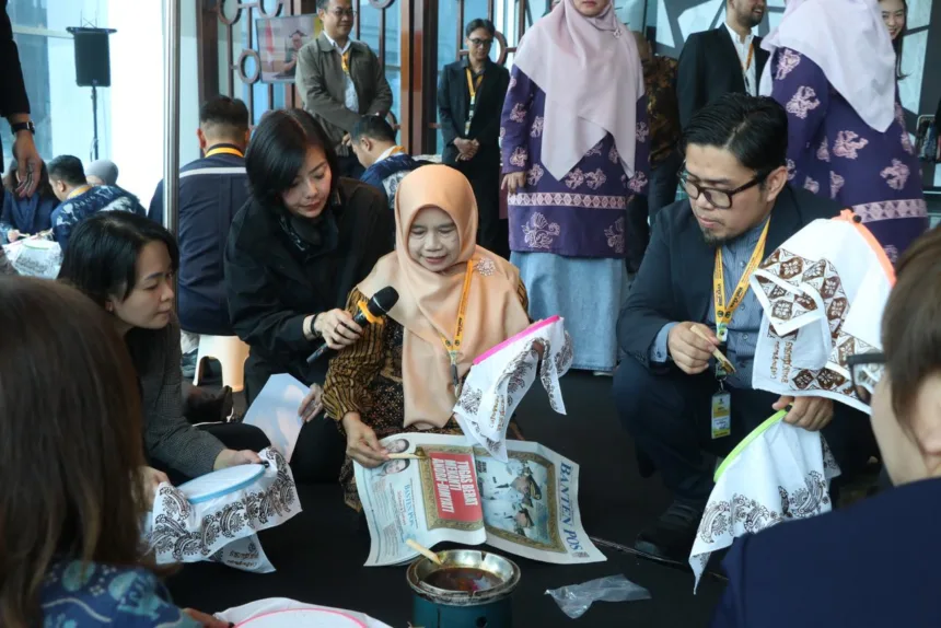 Rina Rahmayanti, S.Pd pemilik Rinara Batik sekaligus Local Hero PLN UID Banten, memandu para delegasi internasional mencoba teknik dasar membatik menggunakan canting.