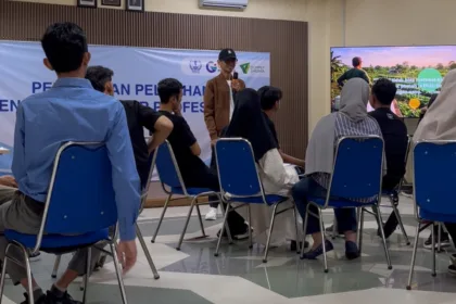 Instruktur Setiawan Chogah memberikan materi literasi finansial Merawat Kebun Rezeki kepada peserta pelatihan Barber, Menjahit, dan Bright Migrant Worker di ruang kelas Institut Kemandirian, Karawaci, Tangerang, dengan presentasi ilustrasi kebun rezeki ditampilkan di layar.